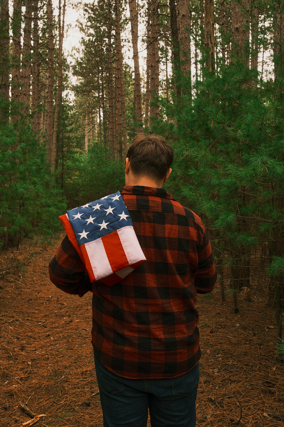 Man walking through the woods with American flag